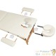 Table de massage pliable en bois beige avec réglage de hauteur et accoudoirs.